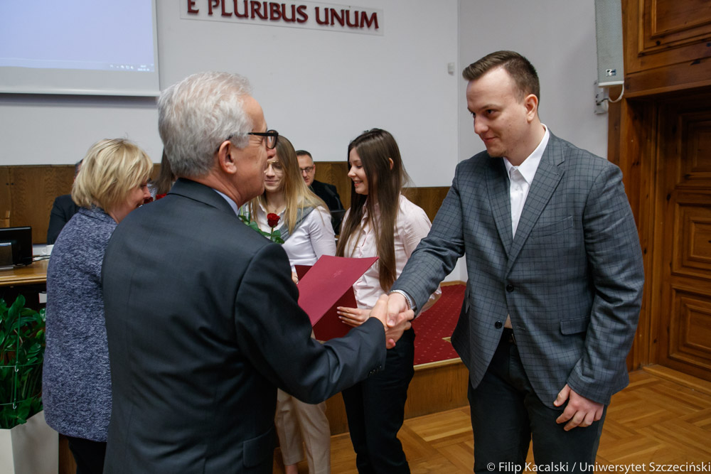 Rektor wręcza list gratulacyjny